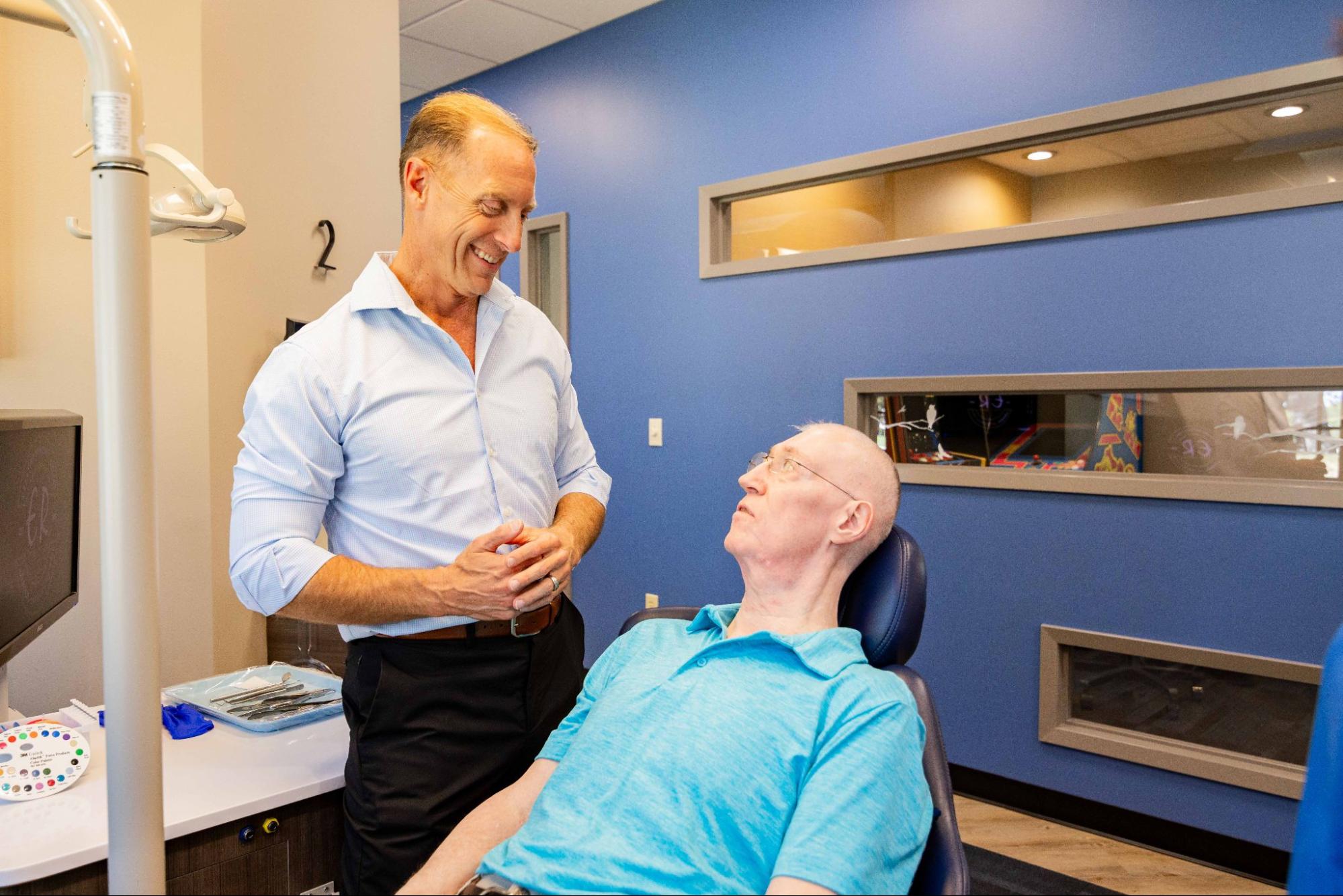 image2 (49) Dentist consulting with a patient in a modern dental office, discussing dental implant options for smile restoration.
